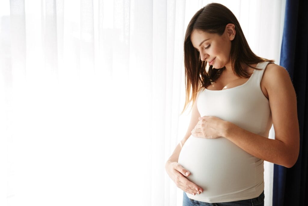 portrait happy pregnant woman touching her belly Large